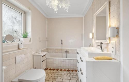 La salle de bains est pourvue de toilettes, d'un lavabo et d'une baignoire. dans l'établissement Pet Friendly Apartment In Carolinensiel With House A Panoramic View, à Carolinensiel
