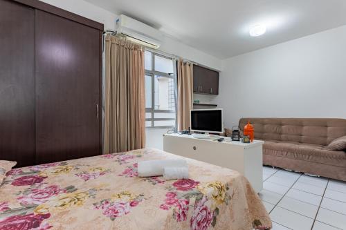 een slaapkamer met een bed en een bank bij Loft completo na Asa Sul próximo da P Federal ENAP LBV Aeroporto CASV , Rodov Interestadual e academia da PM in Brasilia