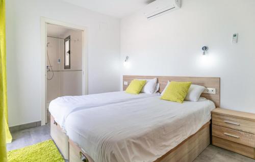 a bedroom with a large white bed with yellow pillows at Amazing Apartment In Fuente De Piedra With Outdoor Swimming Pool in Fuente de Piedra