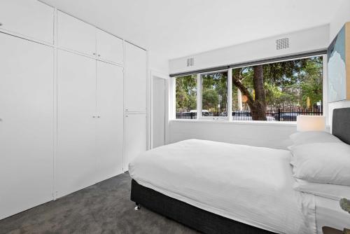 a white bedroom with a bed and a window at Stunning 1-Bed Ground Floor Unit with Front Yard in Melbourne