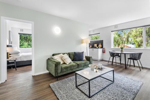 ein Wohnzimmer mit einem Sofa und einem Tisch in der Unterkunft Modern 1-Bed Apartment with Cosy Balcony in Melbourne