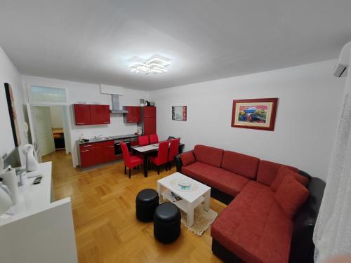 a living room with a red couch and a table at Apartments Mara Cres in Cres