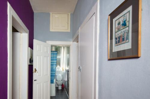 a hallway with a toilet and a picture on a wall at Cozy 2 Bedroom Apartment by Leith Water/ Ocean in Edinburgh