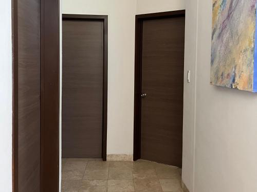 a hallway with three doors and a painting on the wall at La Casa del Agua Puebla in Acatepec