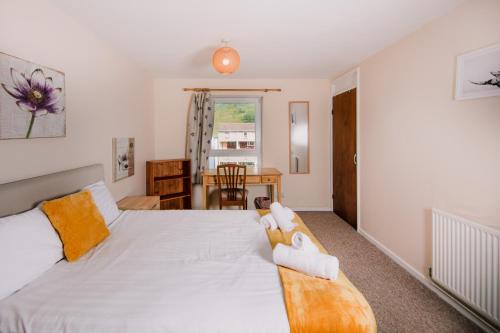 a bedroom with a large white bed with a table at Fab Arthur Seat Views, Old Town Apartment in Edinburgh