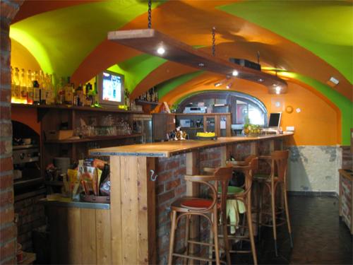 a bar in a restaurant with a green and orange ceiling at Penzion Pod Kašnou in Frýdek-Místek