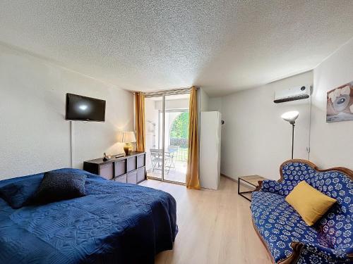 une chambre avec un lit, un canapé et une télévision dans l'établissement Charmant Studio RDC à Lamalou, Terrasse, Proche Thermes, Wifi, Animaux OK - FR-1-451-207, à Lamalou-les-Bains