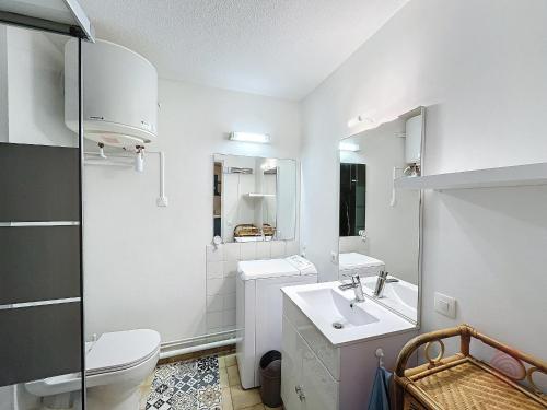 une salle de bain blanche avec des toilettes et un lavabo dans l'établissement Charmant Studio RDC à Lamalou, Terrasse, Proche Thermes, Wifi, Animaux OK - FR-1-451-207, à Lamalou-les-Bains