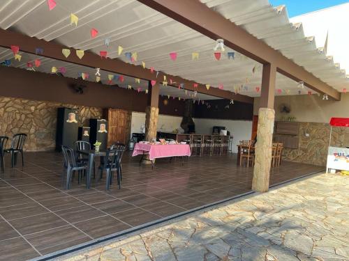 un patio con una mesa rosa y sillas en un edificio en Espaço lerri (chácara completa e muito ampla), en Ribeirão Preto