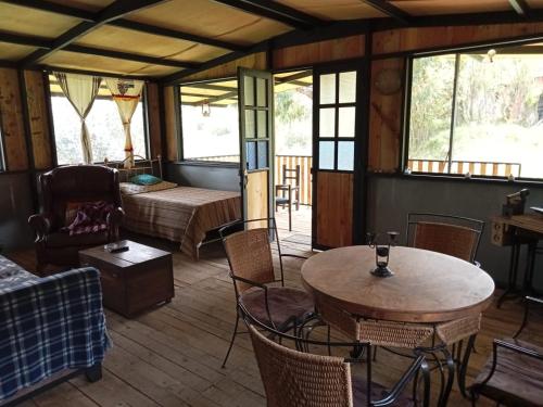 La IslaにあるPosada Turistica Los Josephのベッド、テーブル、椅子が備わる客室です。