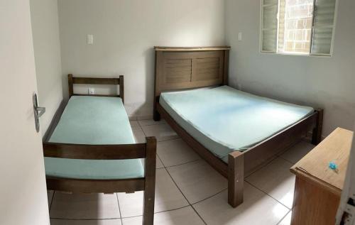 a room with two beds and a chair in it at Chácara R e A eventos in Uberlândia