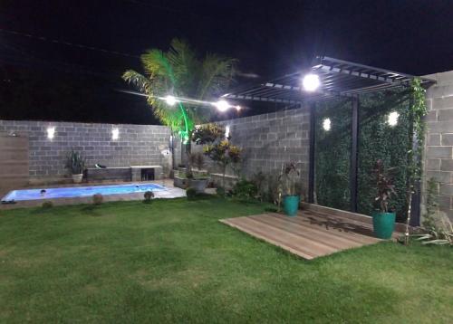 a backyard at night with a swimming pool and lights at Chácara R e A eventos in Uberlândia