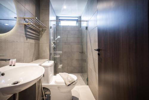 a bathroom with a toilet and a sink and a shower at K Avenue by Pinstay in Donggongon