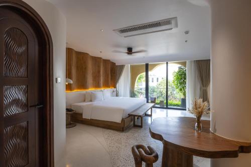 a bedroom with a bed and a desk and a table at Saha Casa Boutique Hotel Da Nang in Da Nang