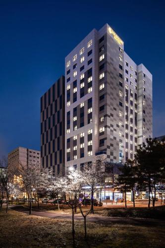 仁川的住宿－Gold Coast Hotel Incheon，前面有树木的高楼