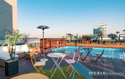 een patio met een tafel en stoelen naast een zwembad bij Gold Coast Hotel Incheon in Incheon