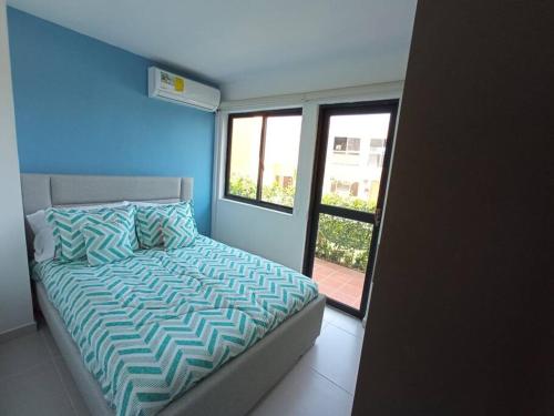 a bedroom with a bed with a blue wall at The Refuge#1 Lovely 2 BR-Apt pool & good vibes in Santa Marta