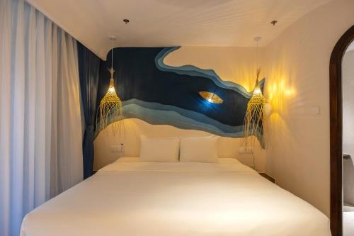 a bedroom with a bed with a painting on the wall at Saha Casa Boutique Hotel Da Nang in Da Nang