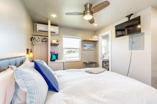 a bedroom with a white bed with a ceiling fan at Beach 5 Villas #B1 in Fernandina Beach