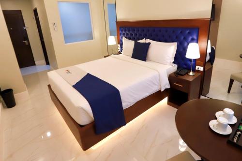 a bedroom with a large bed and a table at Monaco Hotel in Taytay