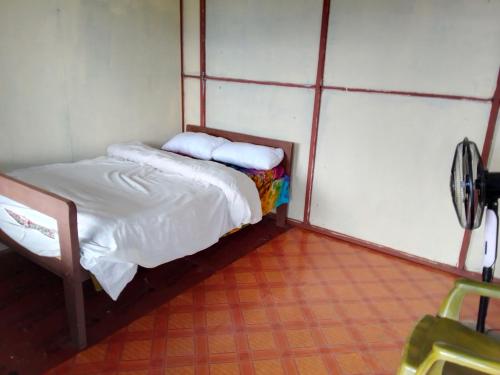 a small bedroom with a bed with white sheets and pillows at Return to Nature Homestay in Nawākot