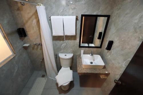 a bathroom with a toilet and a sink at Monaco Hotel in Taytay
