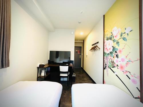 a hotel room with two beds and a tv at Hotel Arashi Namba No002 in Osaka