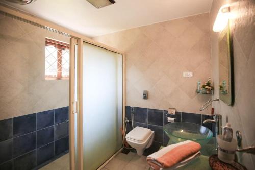 a bathroom with a glass sink and a toilet at Luxury villa with chef/bartender - La Cosa Nostra in Colva