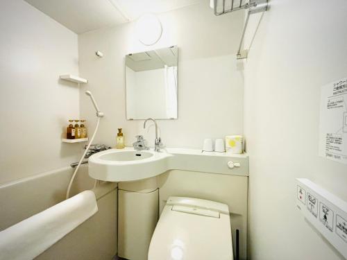a small bathroom with a toilet and a sink at Hotel Arashi Namba No002 in Osaka