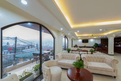 a living room with white furniture and a balcony at Sapa Passion Hotel & Spa in Sa Pa