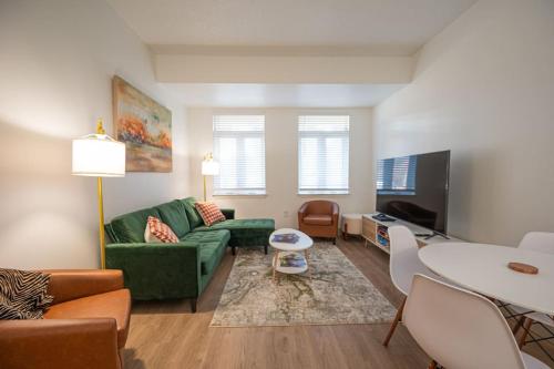 a living room with a green couch and a table at Regal Living in Charlotte