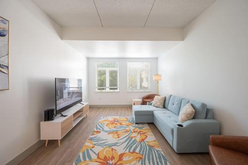 a living room with a blue couch and a tv at Regal Living in Charlotte