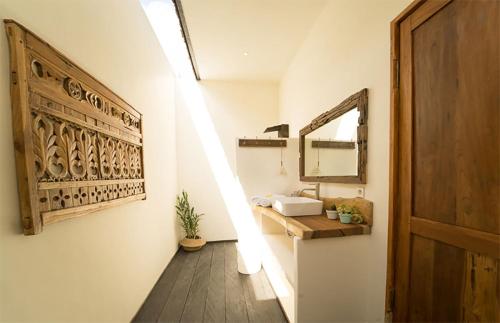 a bathroom with a sink and a mirror on the wall at Villa Kosibali by Optimum Bali Villas in Kerobokan
