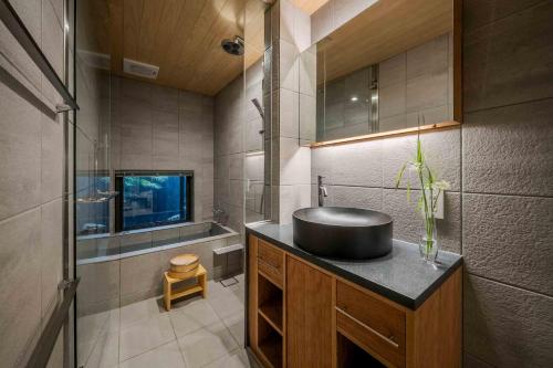 a bathroom with a black sink and a shower at Asagi an Machiya House in Kyoto