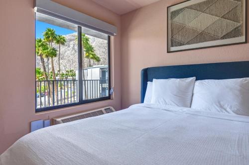 The Dunes Hotel (Palm Springs) في بالم سبرينغز: غرفة نوم بسرير ونافذة