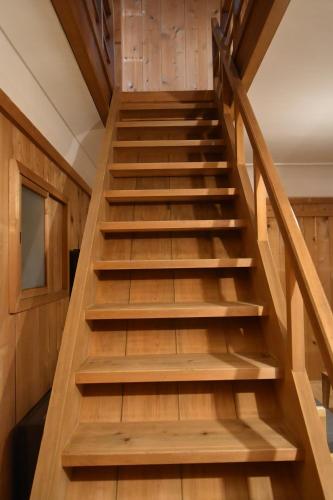 a staircase in a house with wooden steps at 蔵の宿　櫻林亭 in Miwa