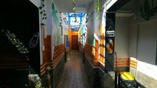 un couloir d'un bâtiment orné de peintures sur les murs dans l'établissement Raymi House Hostel, à Arica