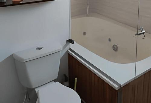 a bathroom with a white toilet and a bath tub at Hermosa finca plan ecológico Brisas de 4 Esquinas in Carmen de Apicalá