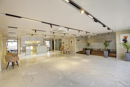 a lobby with a large marble floor and chairs at Saltstayz Premier - Near Golf Course Road & Sector 57 in Gurgaon