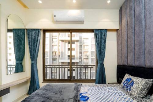 a bedroom with a window with blue curtains and a bed at Swati Homestays in Ahmedabad