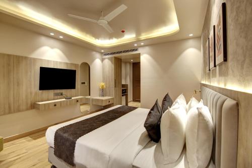 a bedroom with a large bed and a television at Saltstayz Premier - Near Golf Course Road & Sector 57 in Gurgaon