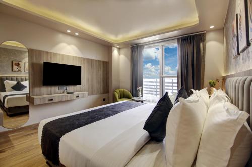a hotel room with a large bed and a television at Saltstayz Premier - Near Golf Course Road & Sector 57 in Gurgaon