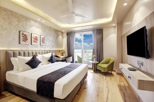 a hotel room with a bed and a television at Saltstayz Premier - Near Golf Course Road & Sector 57 in Gurgaon