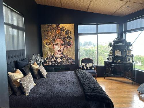 a bedroom with a large painting on the wall at Cloud 9 in Karitane