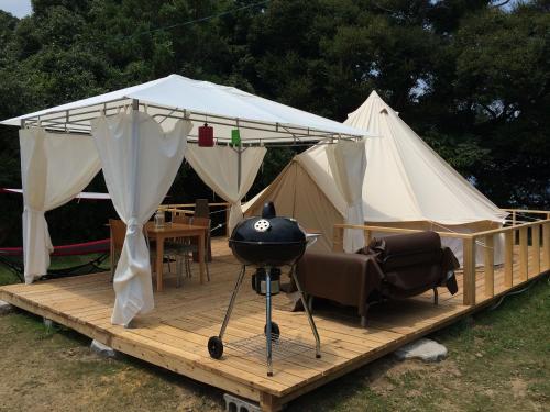 a grill on a wooden deck with a tent at Yamamizuki in Shimanto