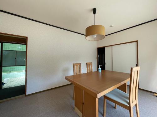 a dining room with a wooden table and chairs at Yamamizuki in Shimanto