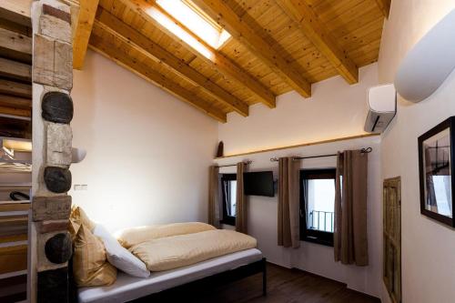 Un dormitorio con una cama en una habitación con techos de madera. en Primavera, en Gargnano