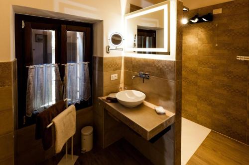 uma casa de banho com um lavatório e um espelho em Primavera - a86157 em Gargnano