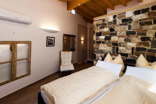 duas camas num quarto com uma parede de pedra em Primavera - a86157 em Gargnano