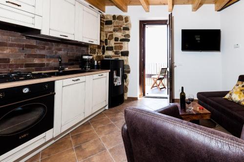 uma cozinha com um fogão e um sofá num quarto em Primavera - a86157 em Gargnano